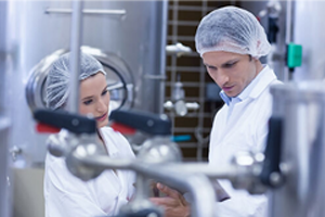 Two people standing in a cooking environment inspecting the containers