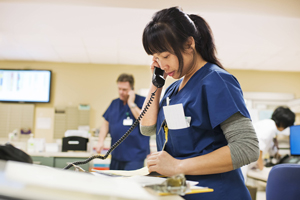 A nurse using a telephone in a hospital waiting room